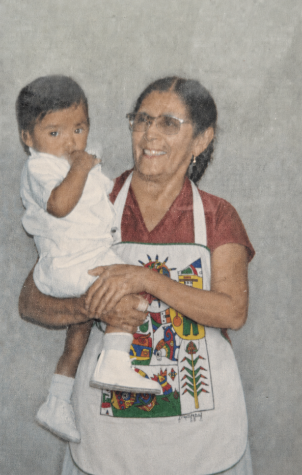 Mama Fina holding David as a child, representing love, artistic roots, and family legacy.